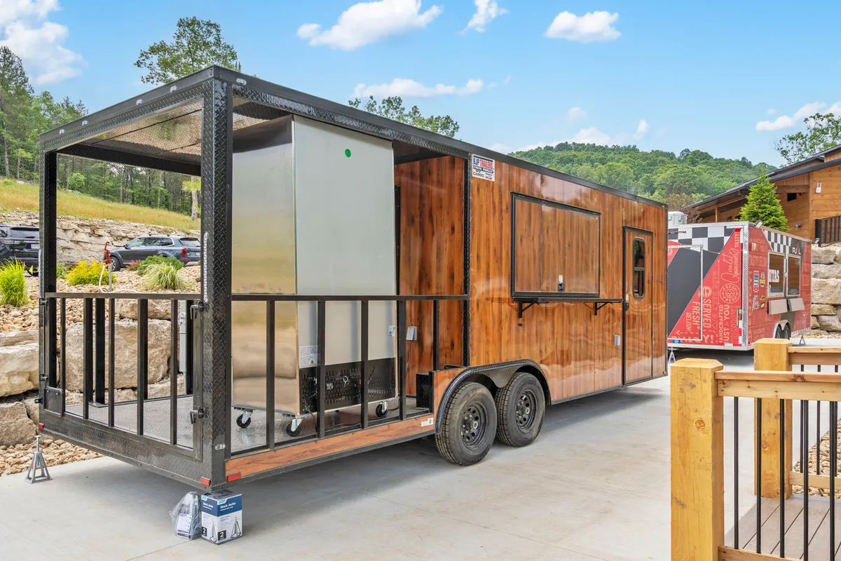A lively exterior scene featuring a food truck trailer nestled in a natural landscape, surrounded by an outdoor seating area. Guests are shown socializing and enjoying food, capturing the communal spirit and the sense of discovery when tasting local dishes.