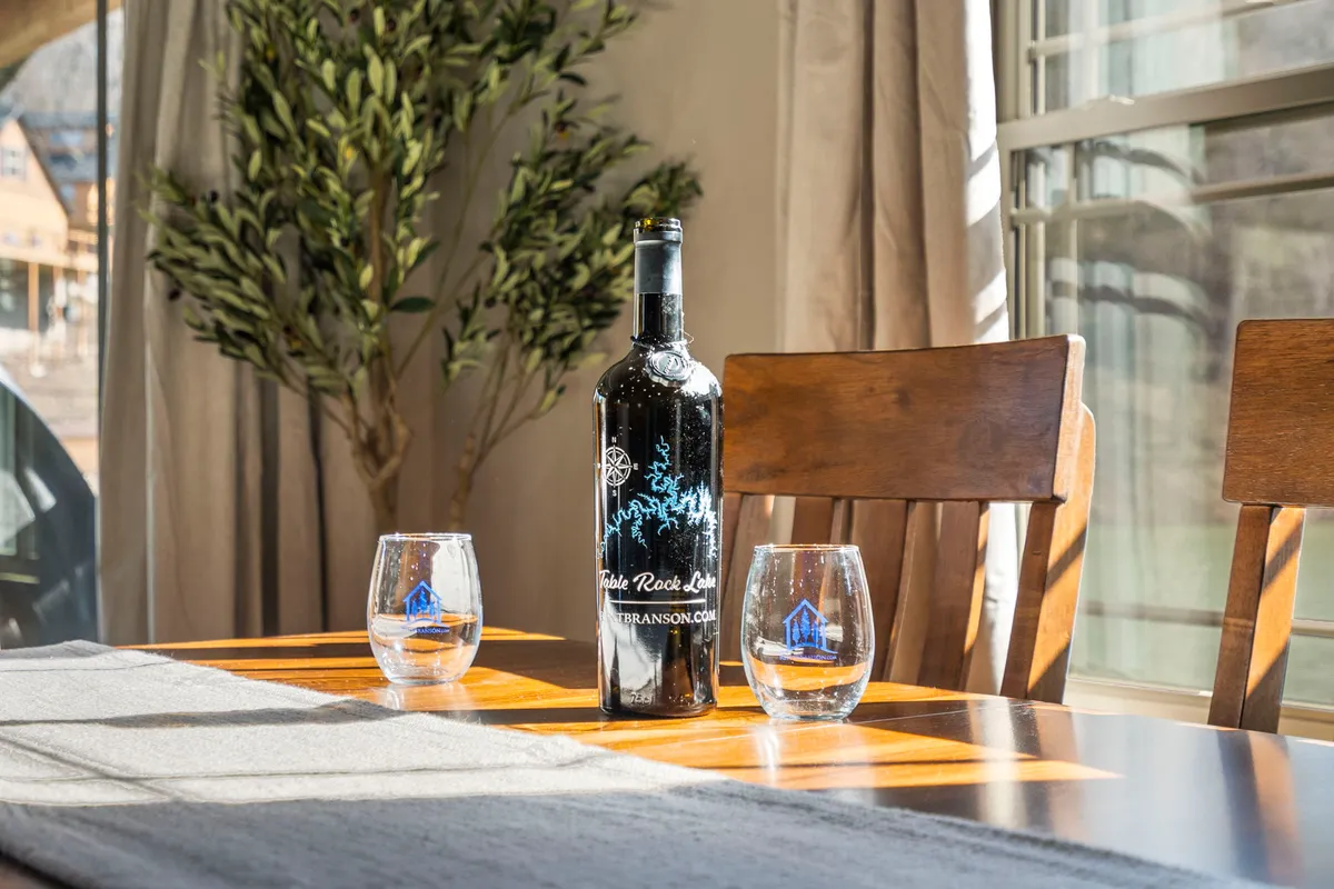 An intimate indoor scene with a wine bottle, two glasses, and an inviting table setting, suggestive of a private wine tasting or cozy dinner. The arrangement is perfect for celebrating special moments.
